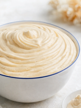 Crème diplomate vanille dans un saladier en céramique blanc à liseret bleu, texture lisse et crémeuse, lumière naturelle douce.