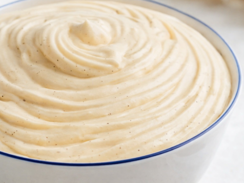 Crème diplomate vanille dans un saladier en céramique blanc à liseret bleu, texture lisse et crémeuse, lumière naturelle douce.