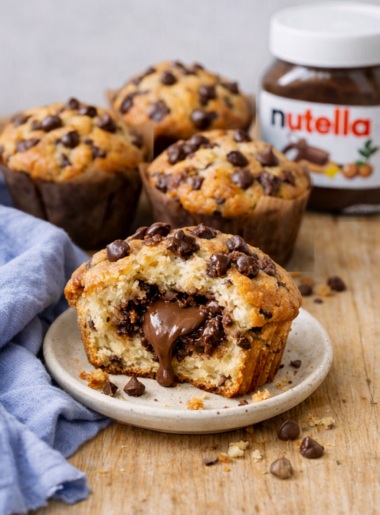 Muffins maison au Nutella, dorés et moelleux, posés sur une table en bois clair avec un chiffon bleu